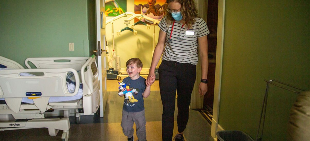 Nurse and child walking in suite at Canuck Place Children's Hospice