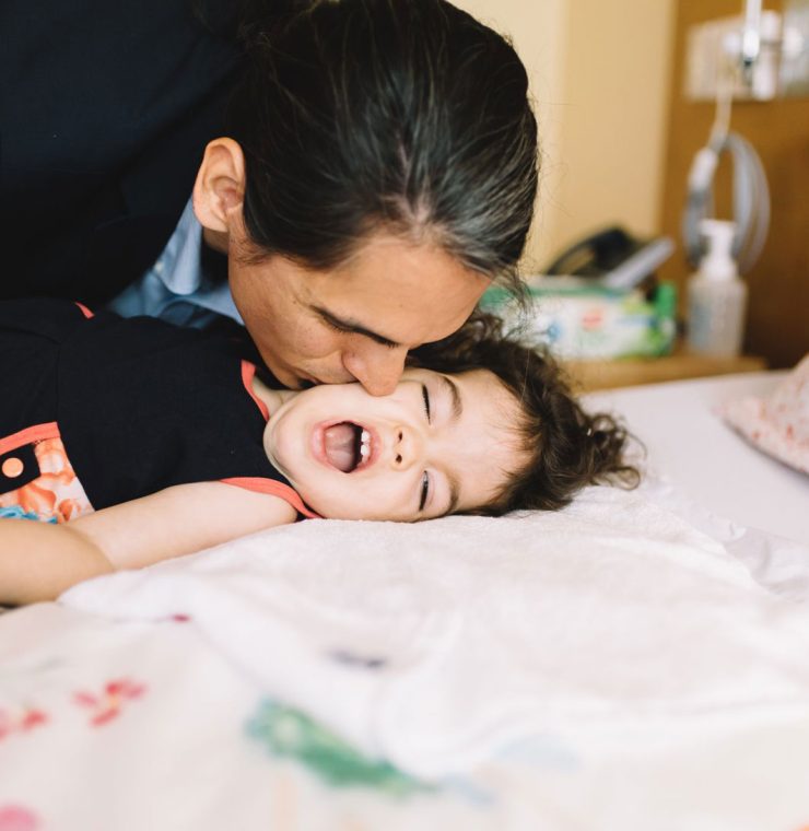 Father kissing child in family suite at Canuck Place Children's Hospice