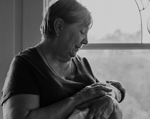 Canuck Place grandmother holding her baby by the window in black and white