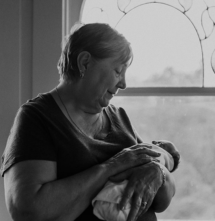 Canuck Place grandmother holding her baby by the window in black and white
