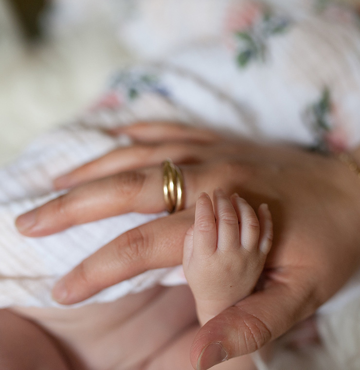 Canuck Place baby holding mother's hand close up