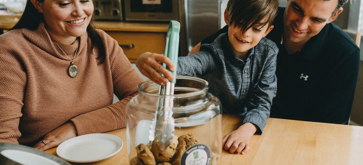 Canuck Place family eating cookies together at Canuck Place kitchen