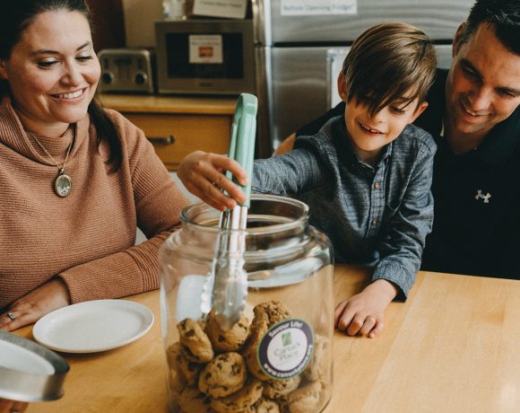 Canuck Place family eating cookies together at Canuck Place kitchen