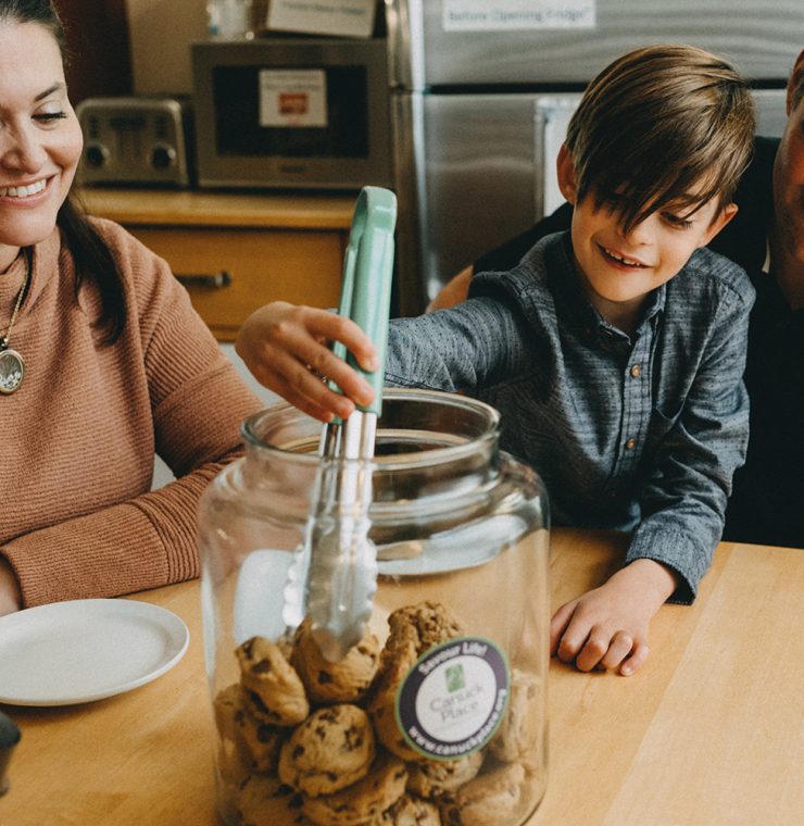 Canuck Place family eating cookies together at Canuck Place kitchen