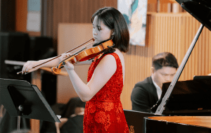 Rachel Wei playing her violin at a fundraising concert