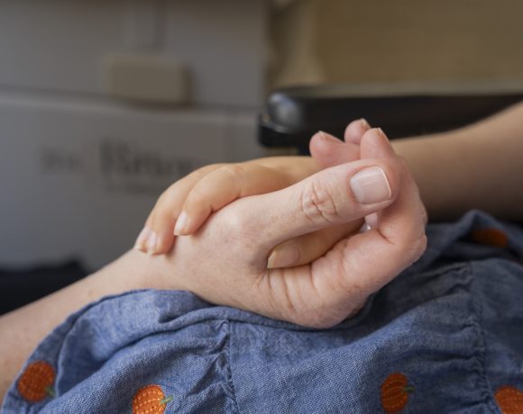 Close up of a nurse holding a child's hand