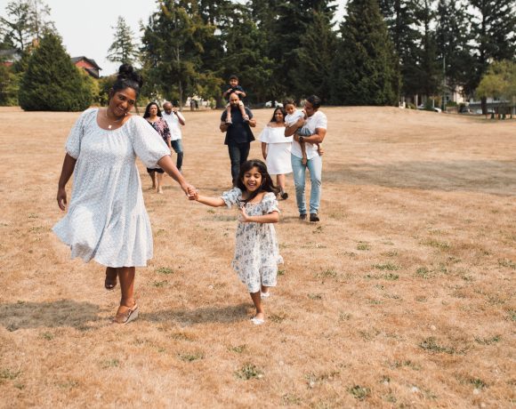 Group of people walking and skipping across a field outside