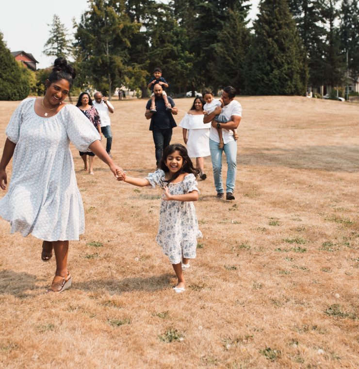 Group of people walking and skipping across a field outside