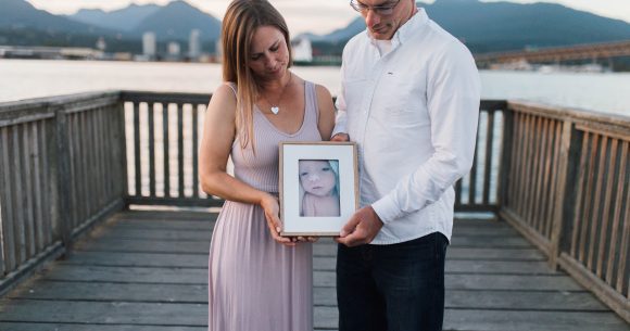 Canuck Place parents holding photo of their baby