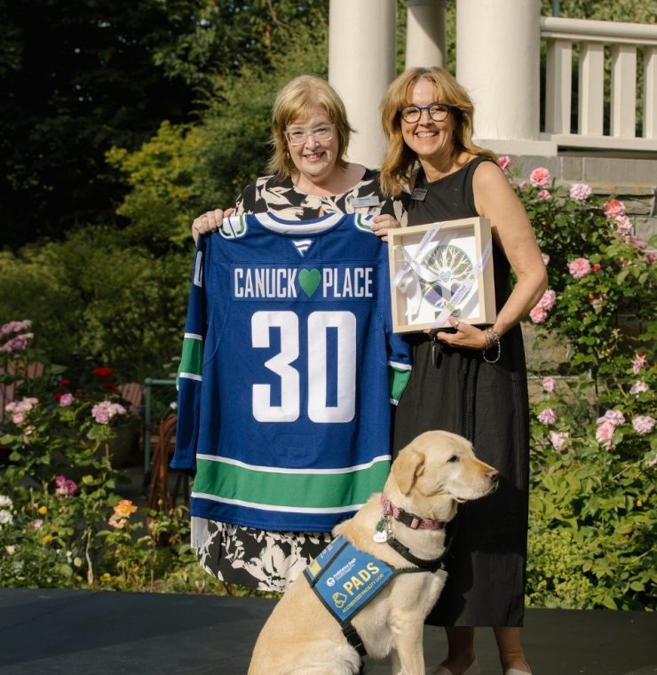 Canuck Place CEO Denise Praill honouring Camara van Breemen for 30 years of service at Canuck Place, accompanied by Canuck Place's PADS accredited facilities dog, Gaia
